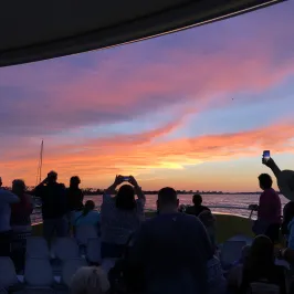 a group of people watching a band on stage in front of a crowd